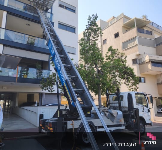 מנוף משאית ליד בניין מגורים